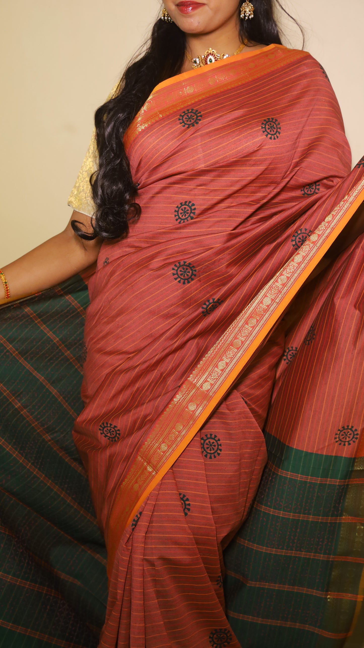 Timeless maroon saree with subtle linear texture, bold navy-blue sun motifs and with a dual-tone zari border in orange and green - VARSHIKA