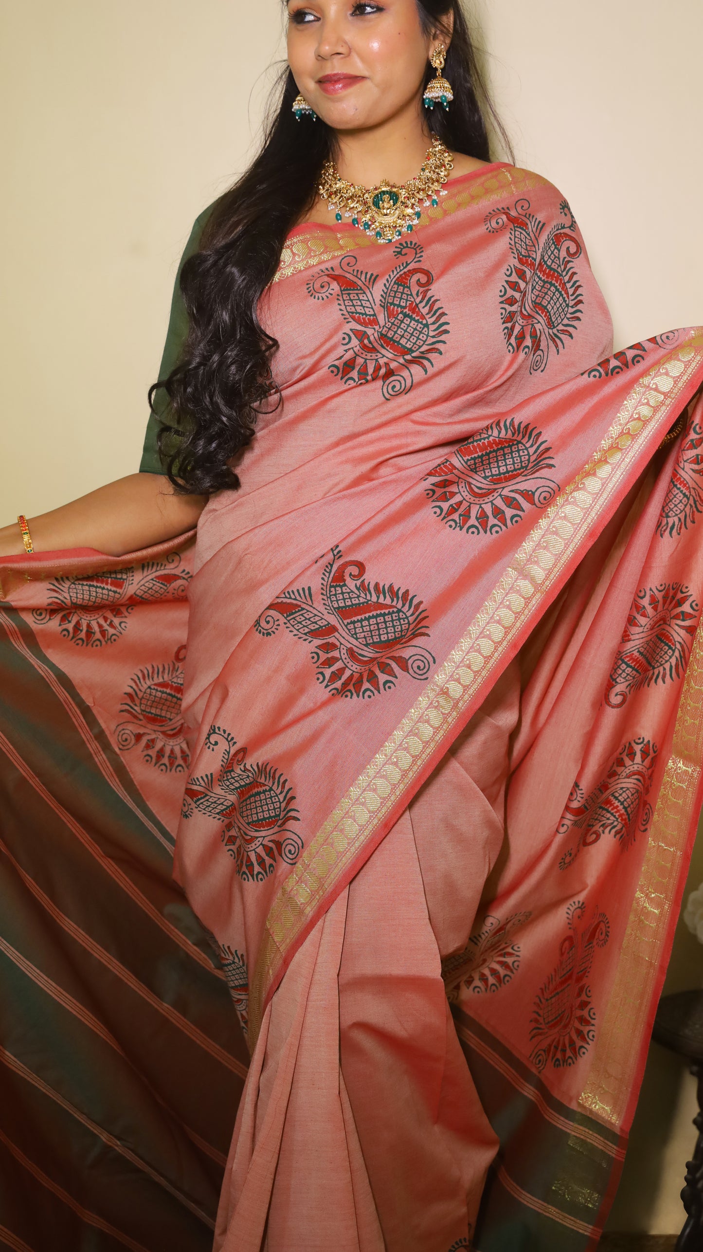Stunning muted pink saree featuring bold paisley motifs in dark threadwork along the golden border - VARSHIKA