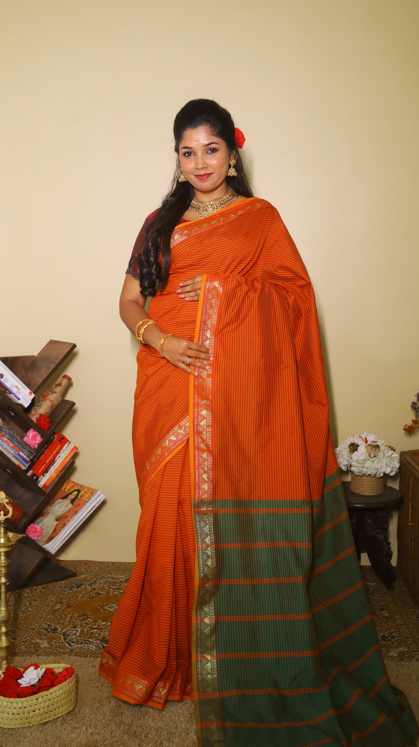 Striking rust-orange saree with fine black pinstripes and a contrasting green pallu with textured zari border and playful tassels- VARSHIKA