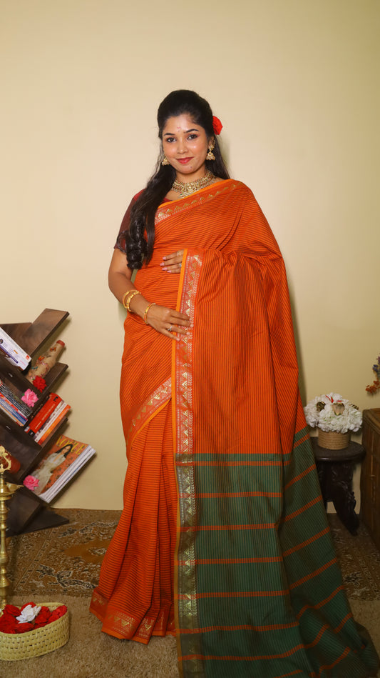 Striking rust-orange saree with fine black pinstripes and a contrasting green pallu with textured zari border and playful tassels- VARSHIKA
